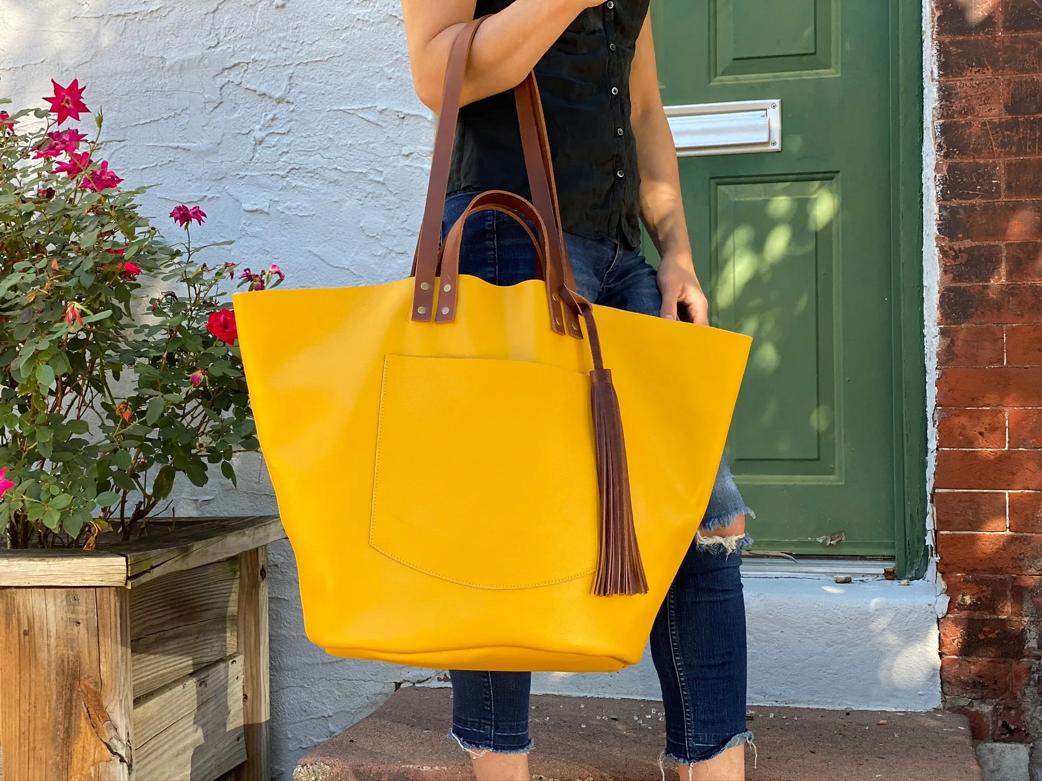 Large yellow leather tote with feather tassels
