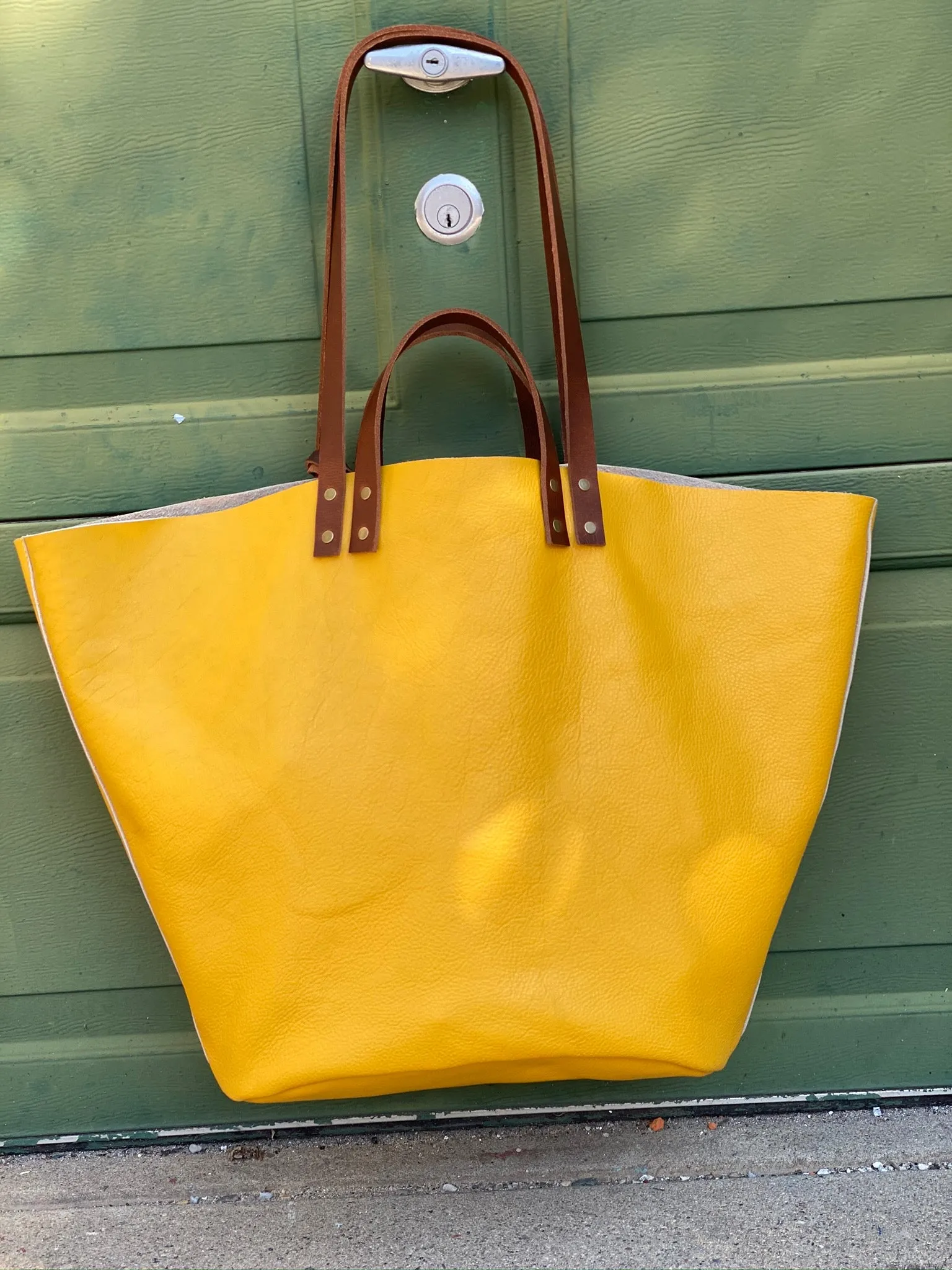 Large yellow leather tote with feather tassels