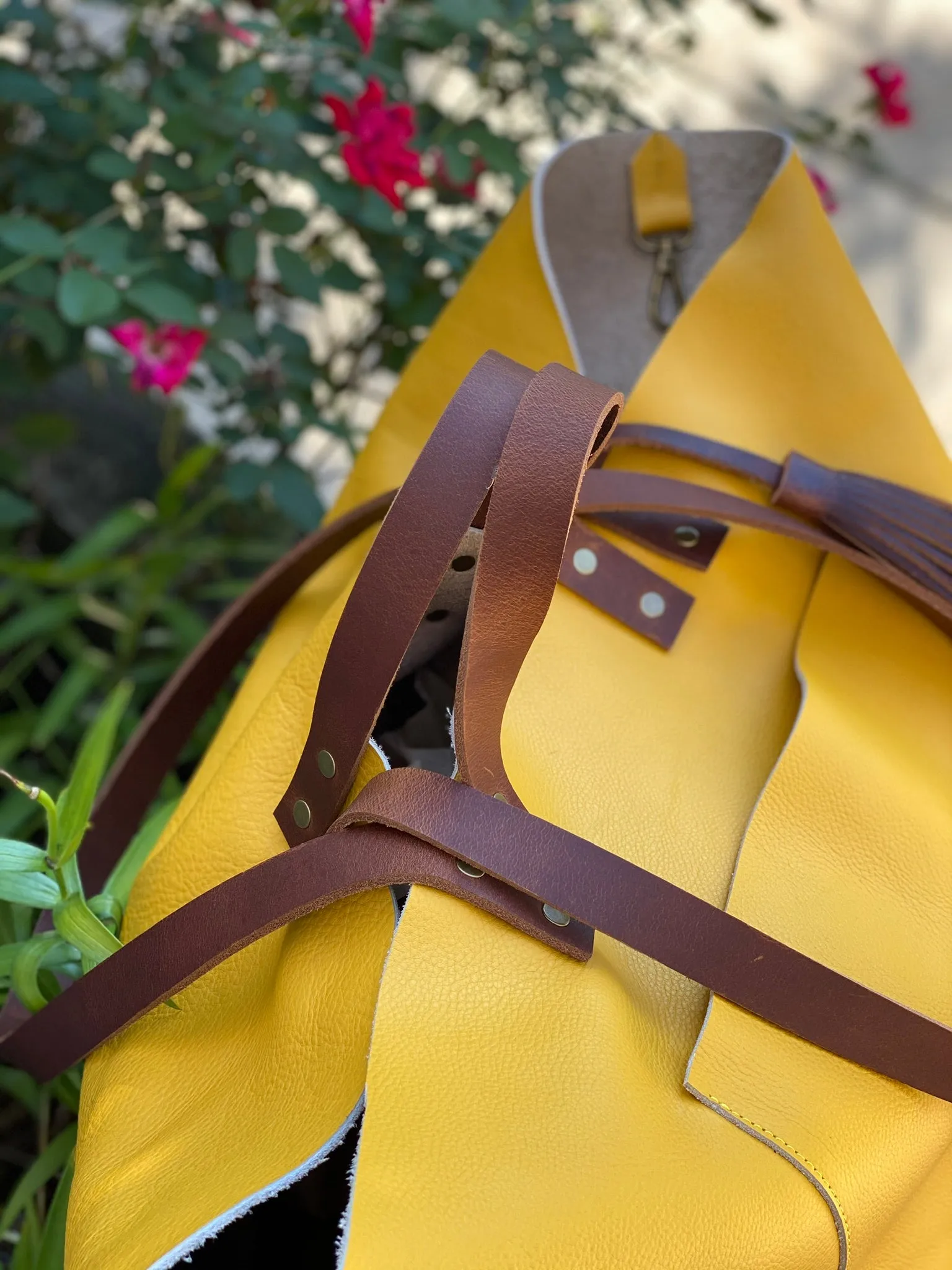 Large yellow leather tote with feather tassels