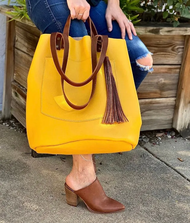 Large yellow leather tote with feather tassels