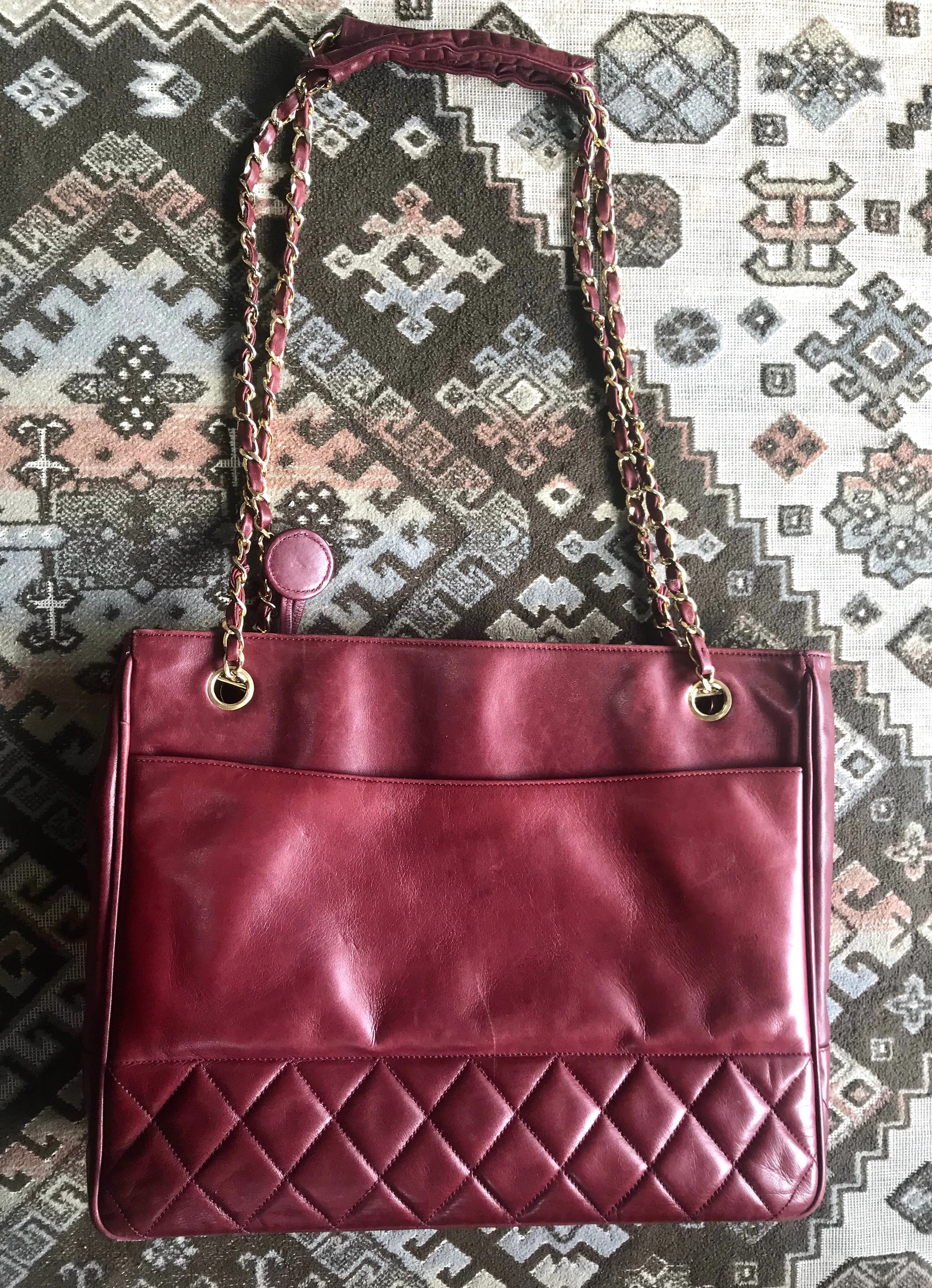 Vintage CHANEL wine leather tote bag with gold chain handles and CC motif charm. Classic purse.