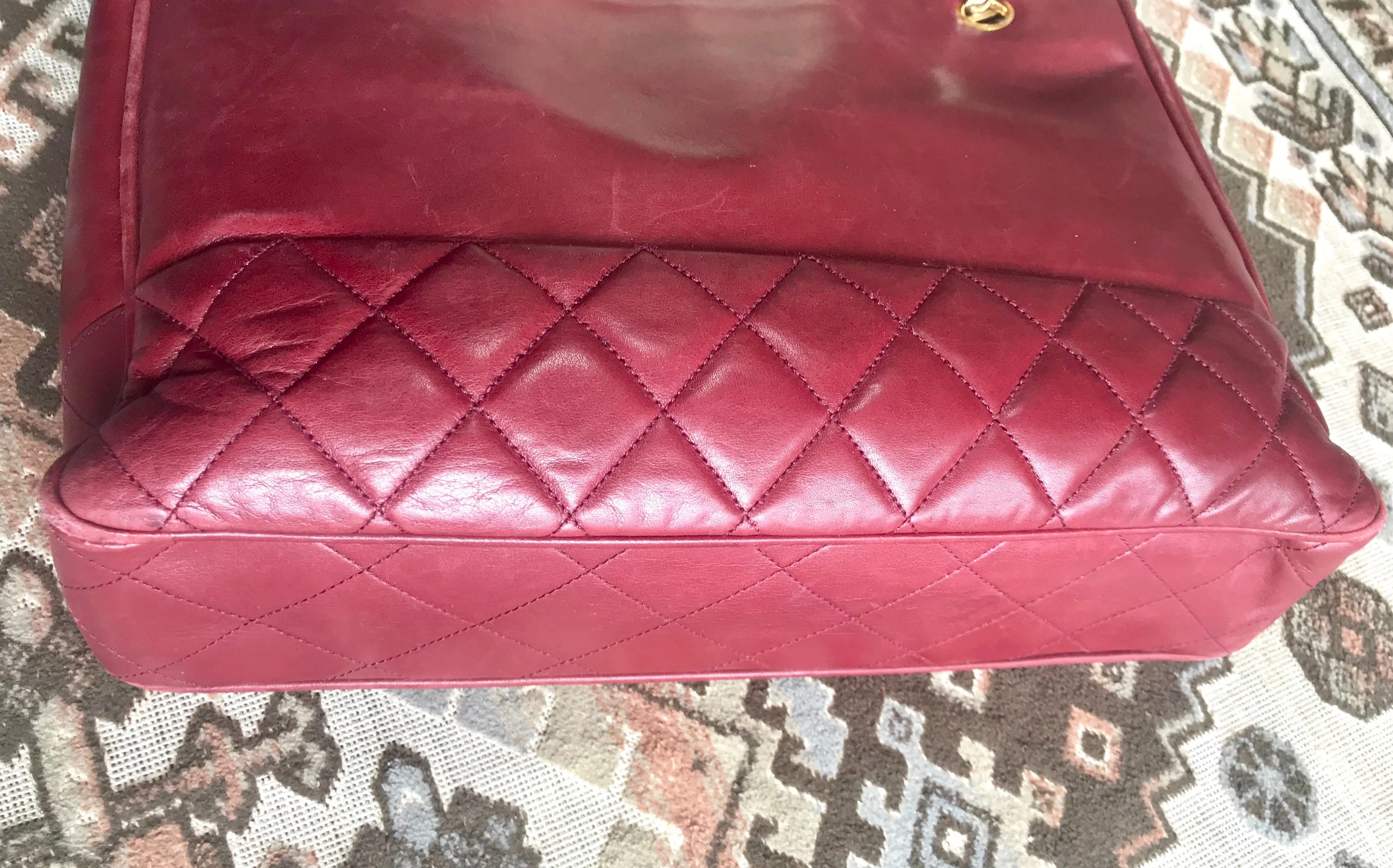 Vintage CHANEL wine leather tote bag with gold chain handles and CC motif charm. Classic purse.