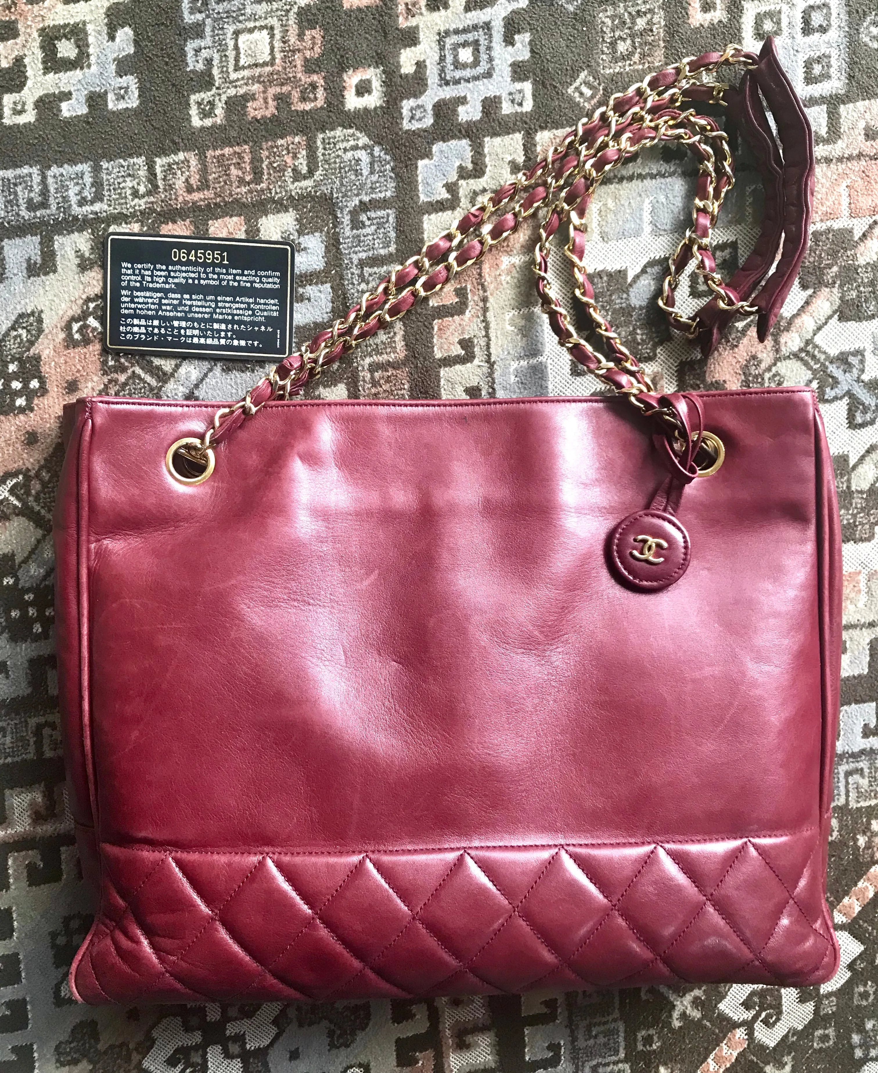 Vintage CHANEL wine leather tote bag with gold chain handles and CC motif charm. Classic purse.