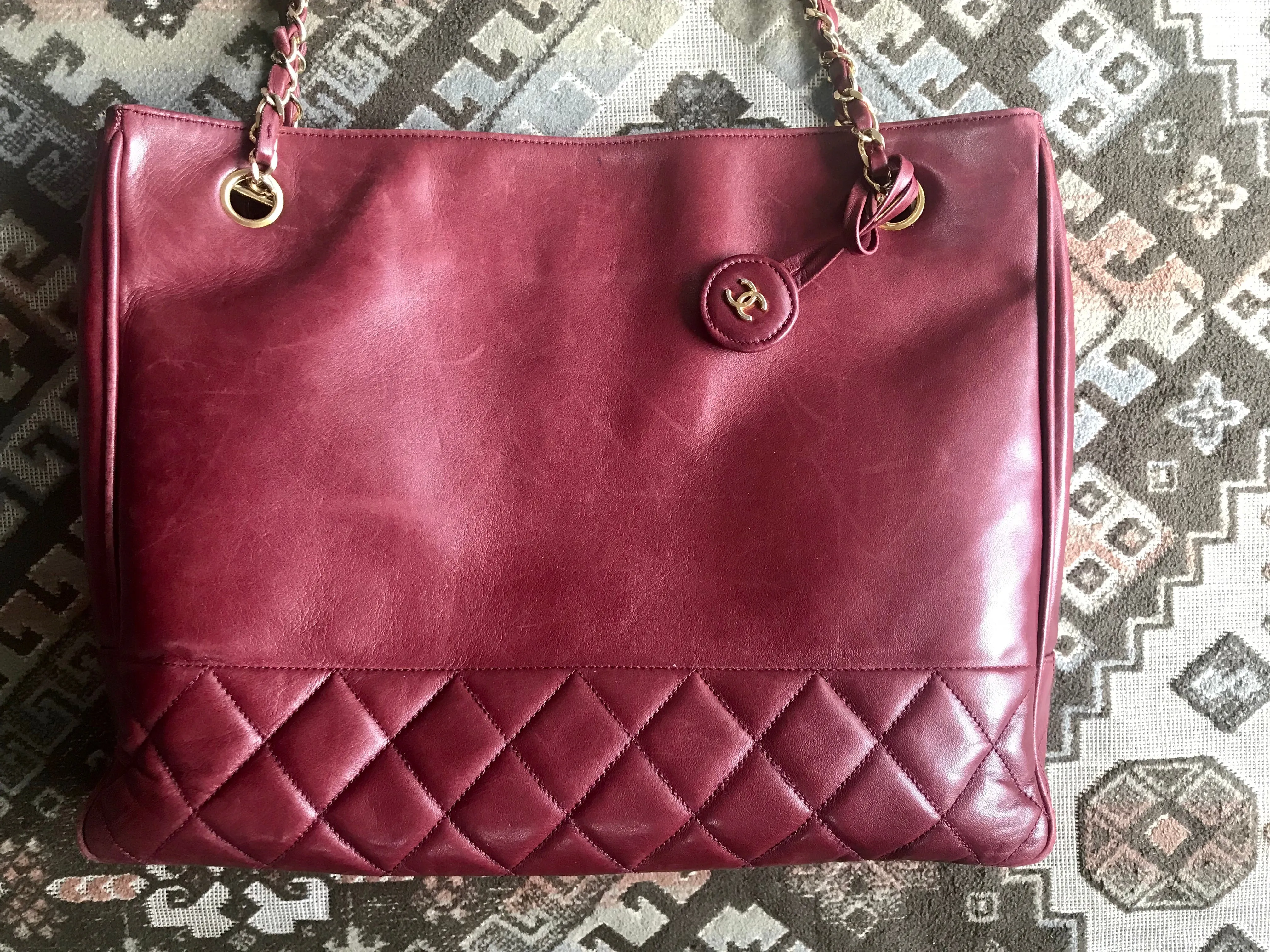 Vintage CHANEL wine leather tote bag with gold chain handles and CC motif charm. Classic purse.